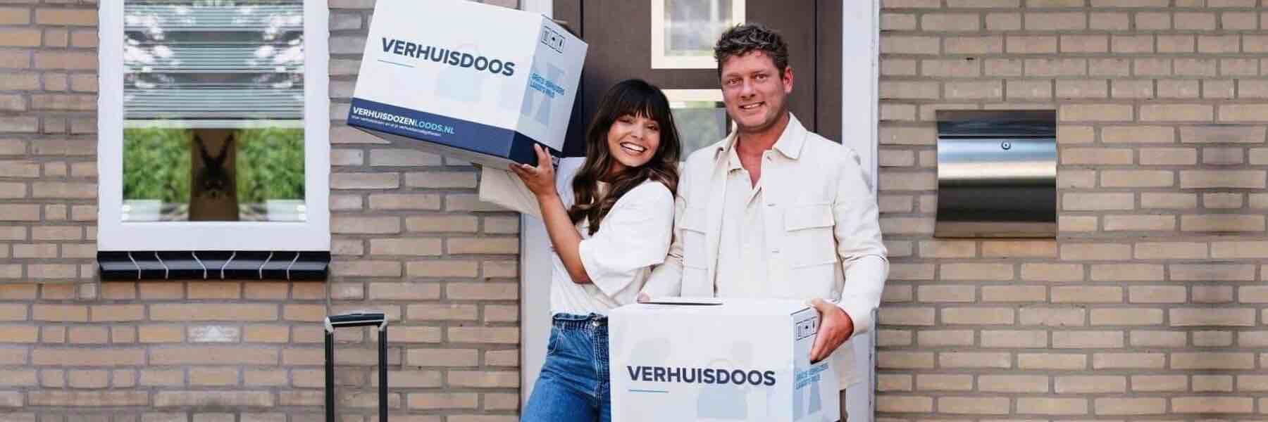 blij koppel met verhuisboxen in de handen