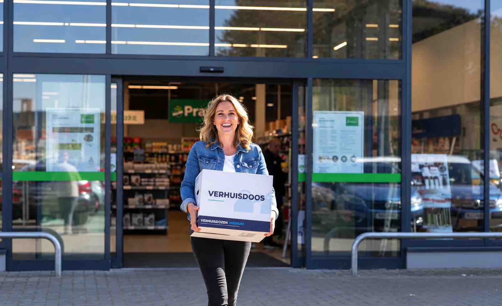vrouw met verhuisdozenloods verhuisdoos loopt winkel uit